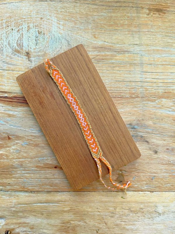Bracelet fin et coloré sur un support en bois